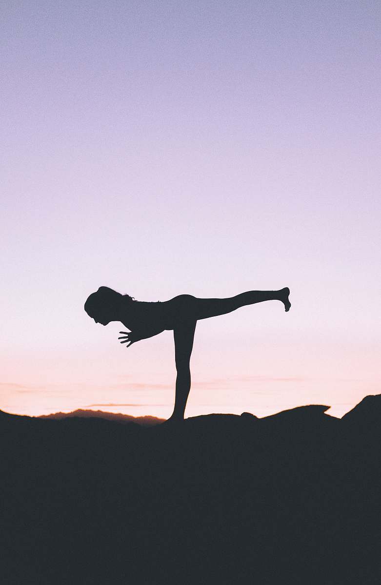 working out silhouette photography of woman standing on right foot yoga